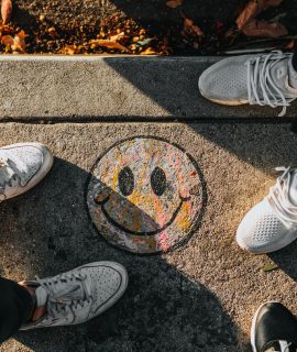 smiley paint on gray ground in front of people